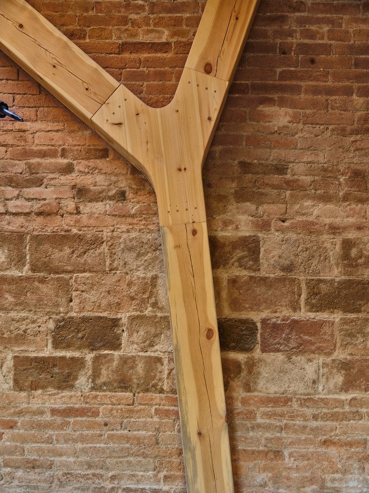 Detail of a timber Y-junction against the reused brick wall.