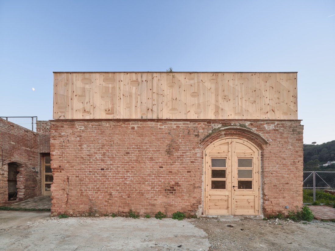 The exterior of the new timber addition features an engraved voronoi pattern hinting at the cellular geometry of the interior vault structure.