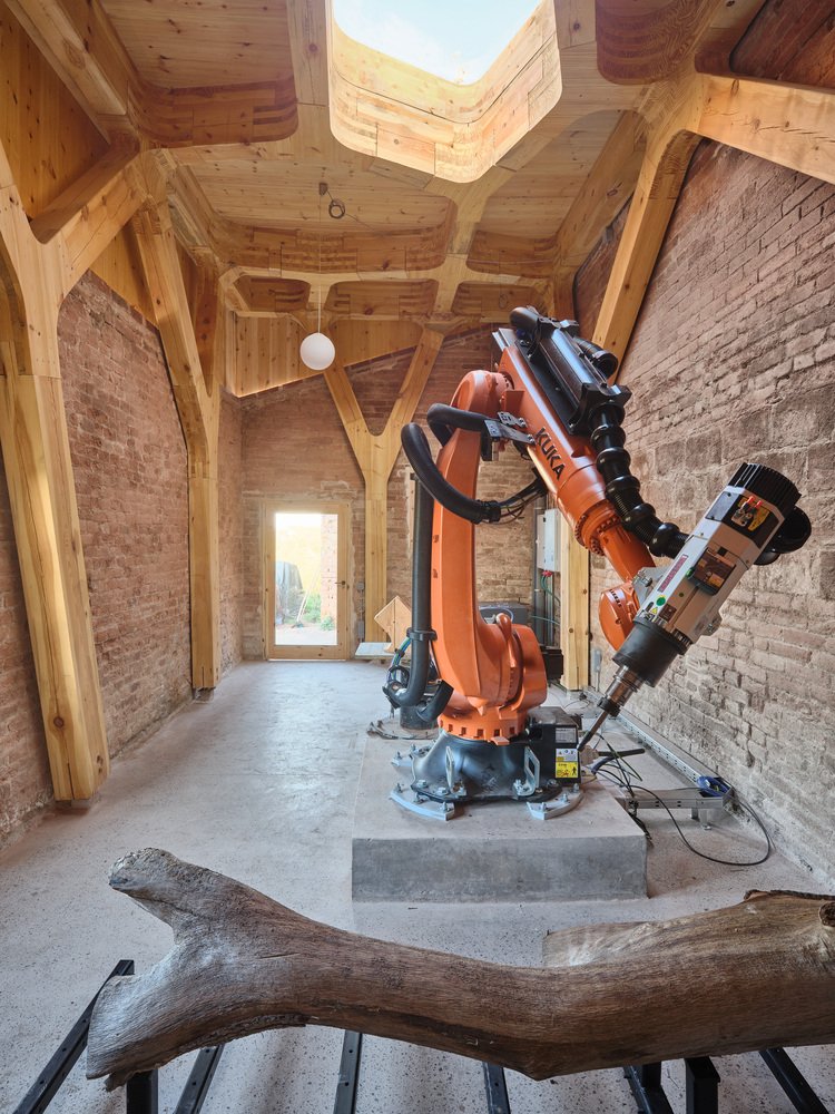 The robotic arm operating on an organically shaped log.