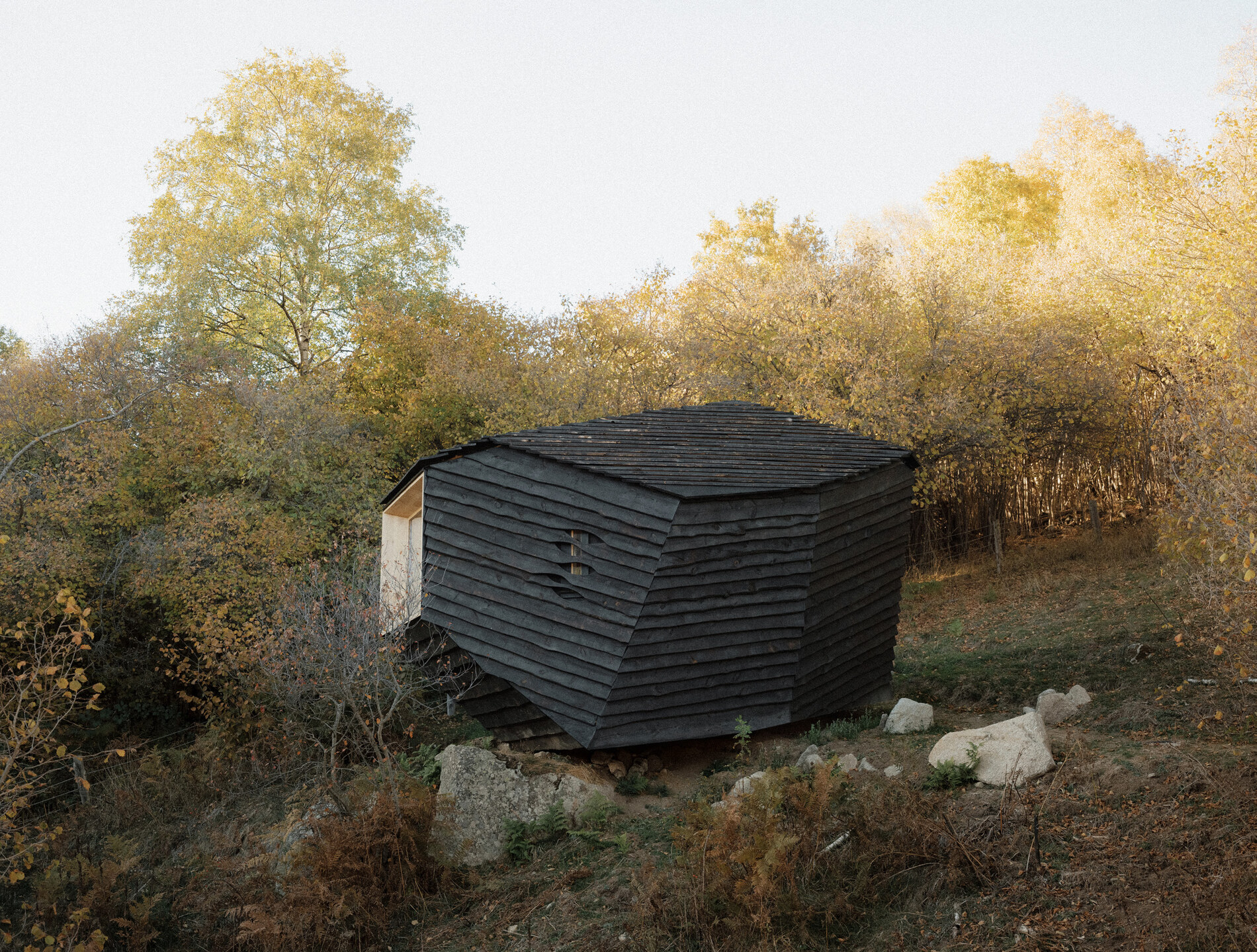 The cabin in autumn, sitting on its boulders.