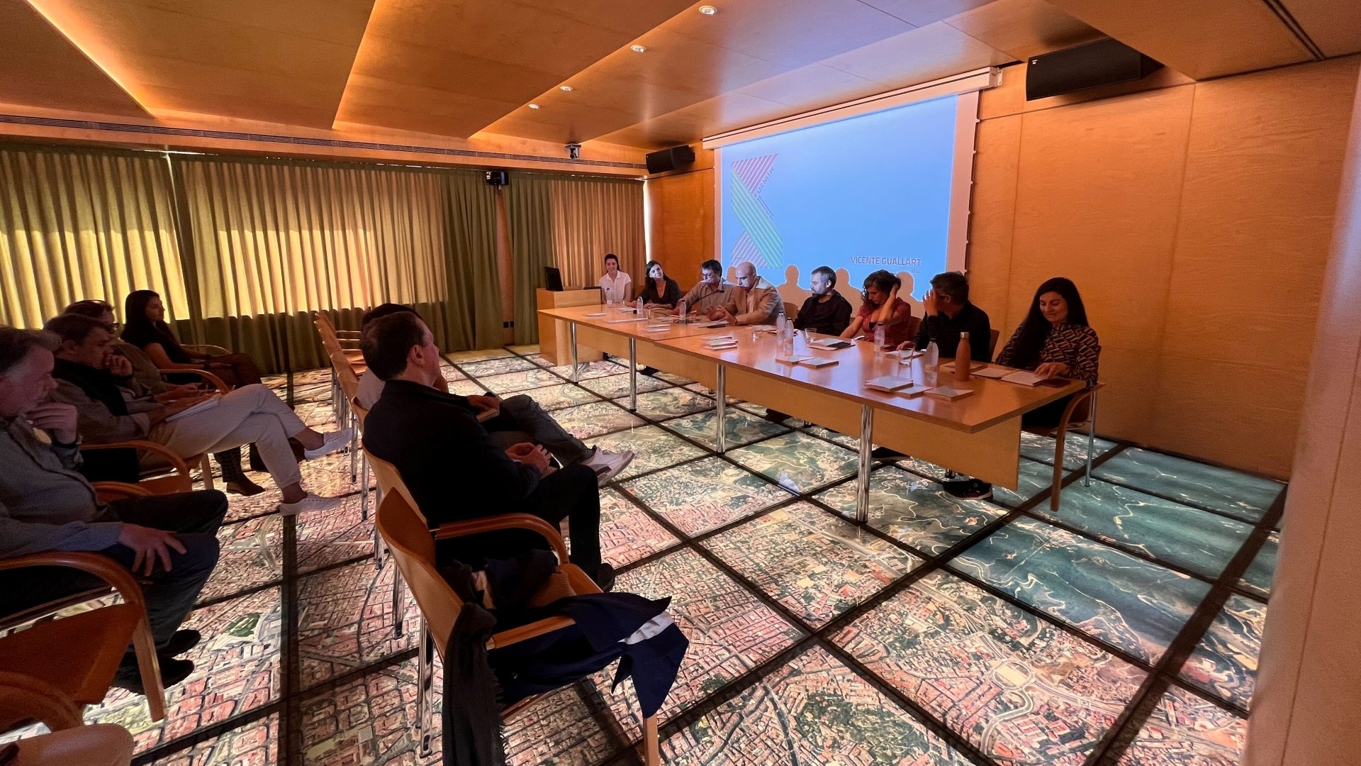 Vicente Guallart presenting the book at its Barcelona release, held above a floor-projected map of the city.