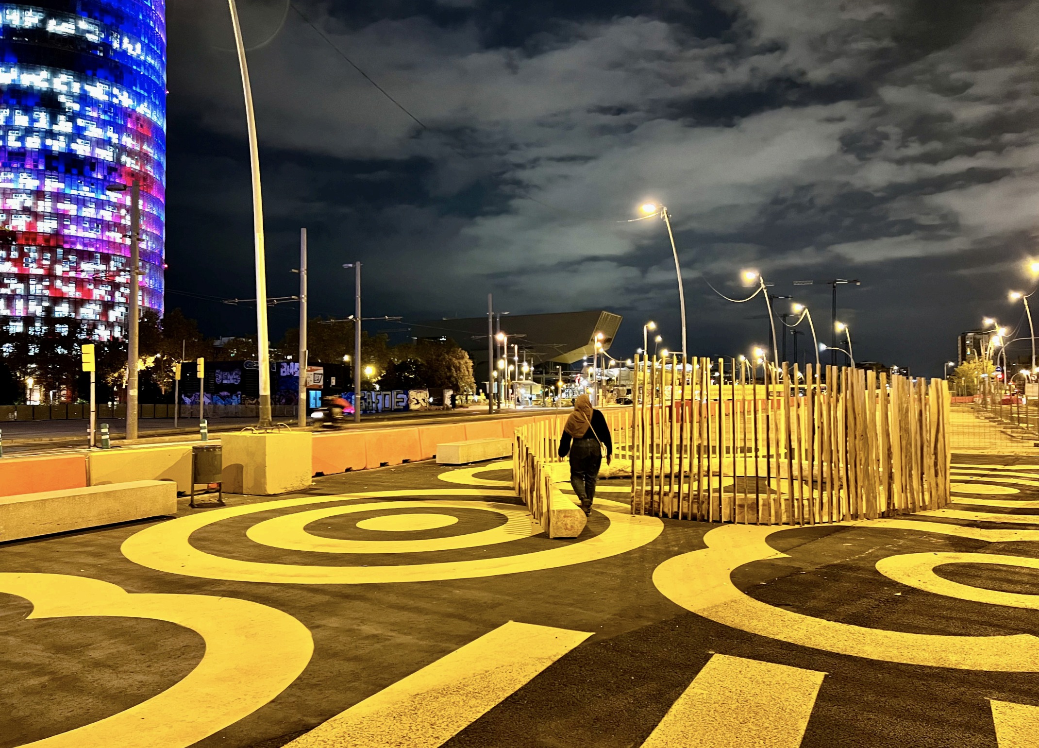 El Cargol at night, lit against the plaza's painted circles.