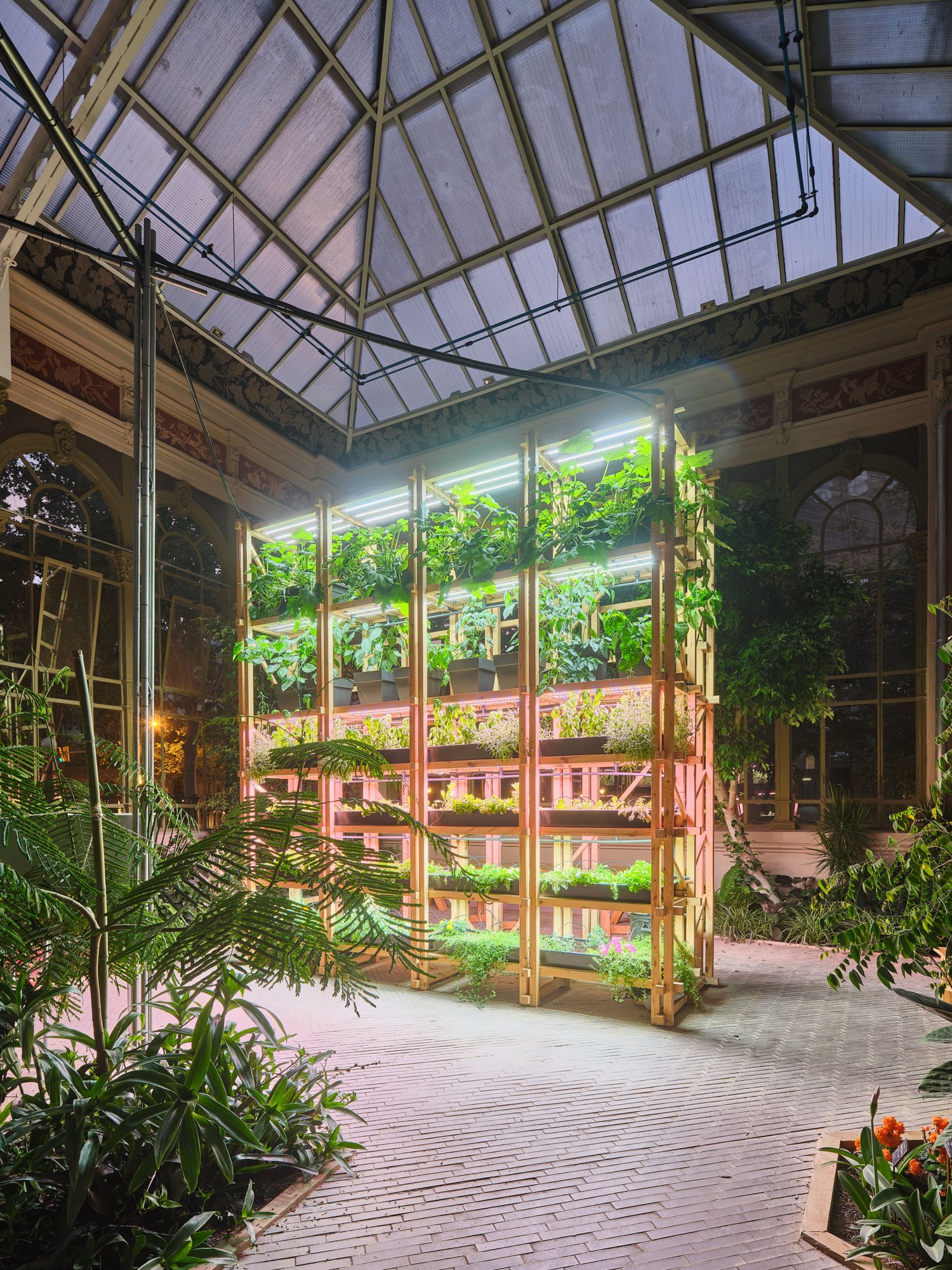 The modular vertical planting system integrates hydroponic and grow light systems.
