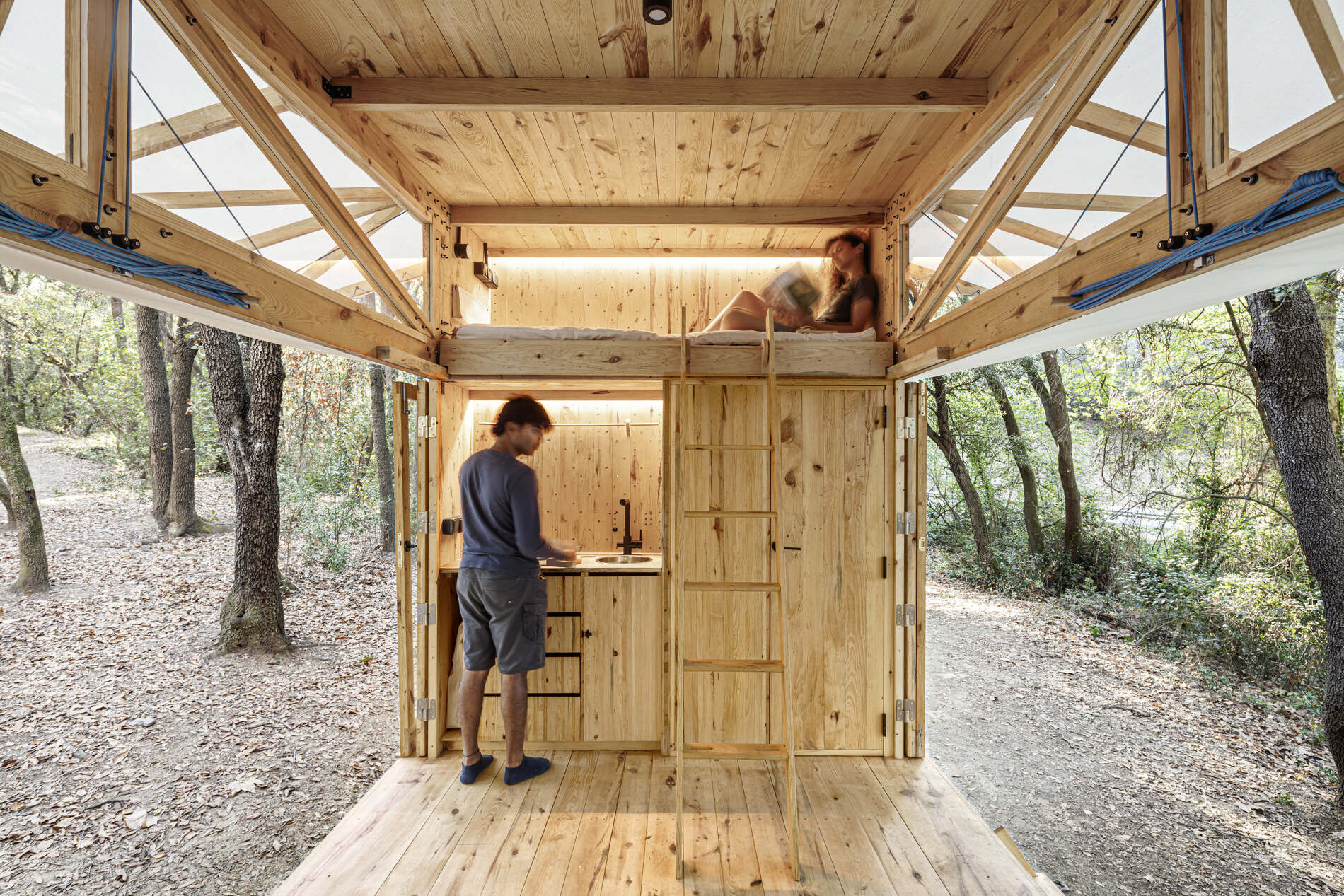 Both long sides folded away — the forest becomes the room.