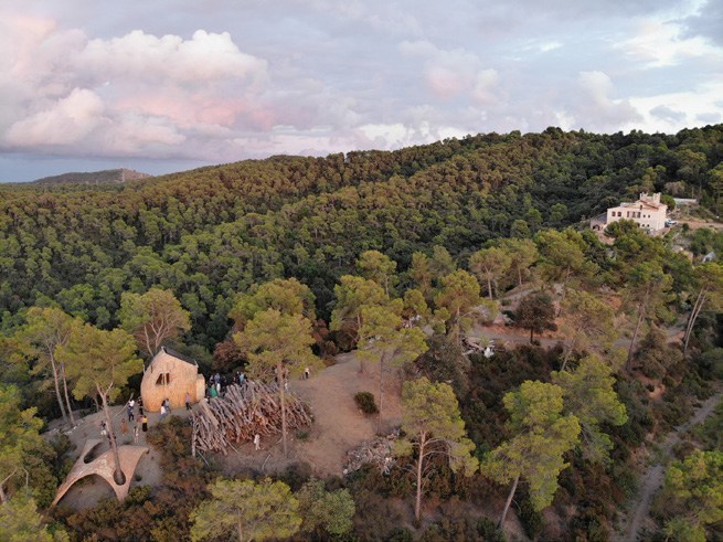 The cabin seen from above within the greater forest.
