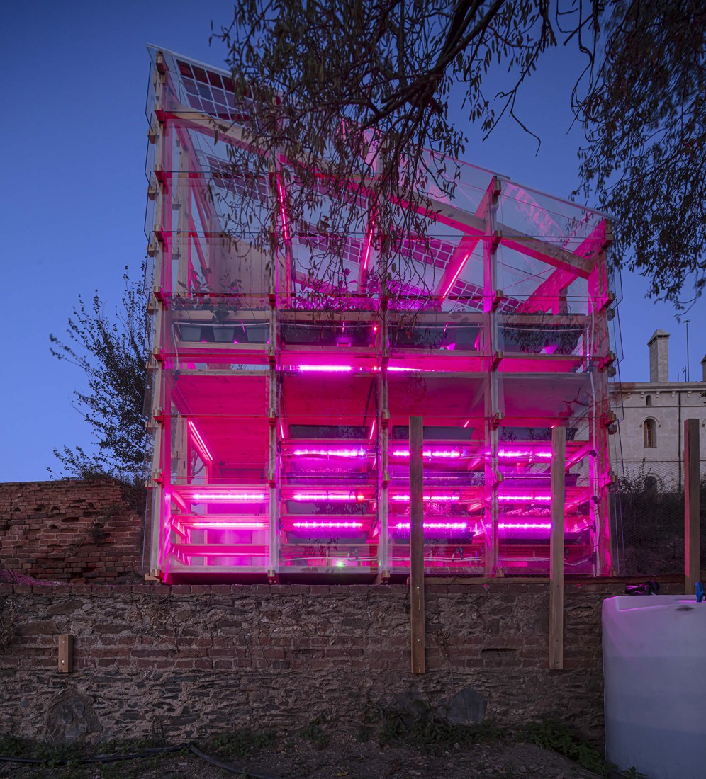 Old masia wall and new growing tower, lit for the night.