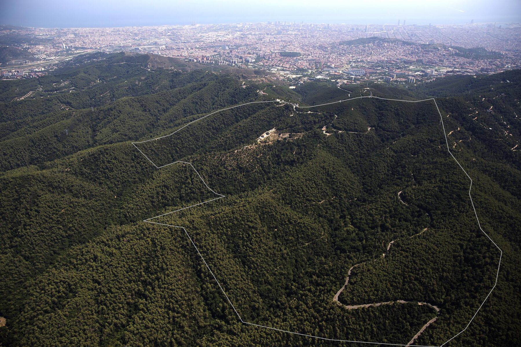 The estate's boundary within Collserola, with Barcelona and the Mediterranean beyond.